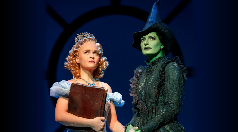 Glinda and Elphaba Holding Hands and Looking Off Into the Distance