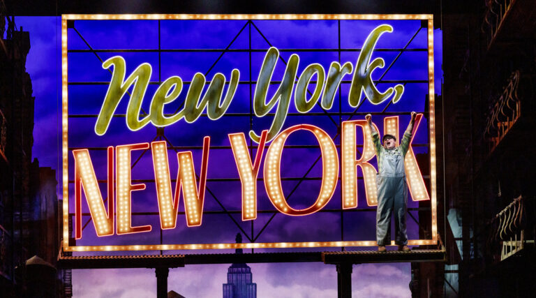 A man standing on New York, New York neon sign.