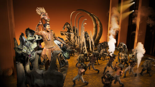 Stephen Carlile as Scar and the cast of The Lion King.